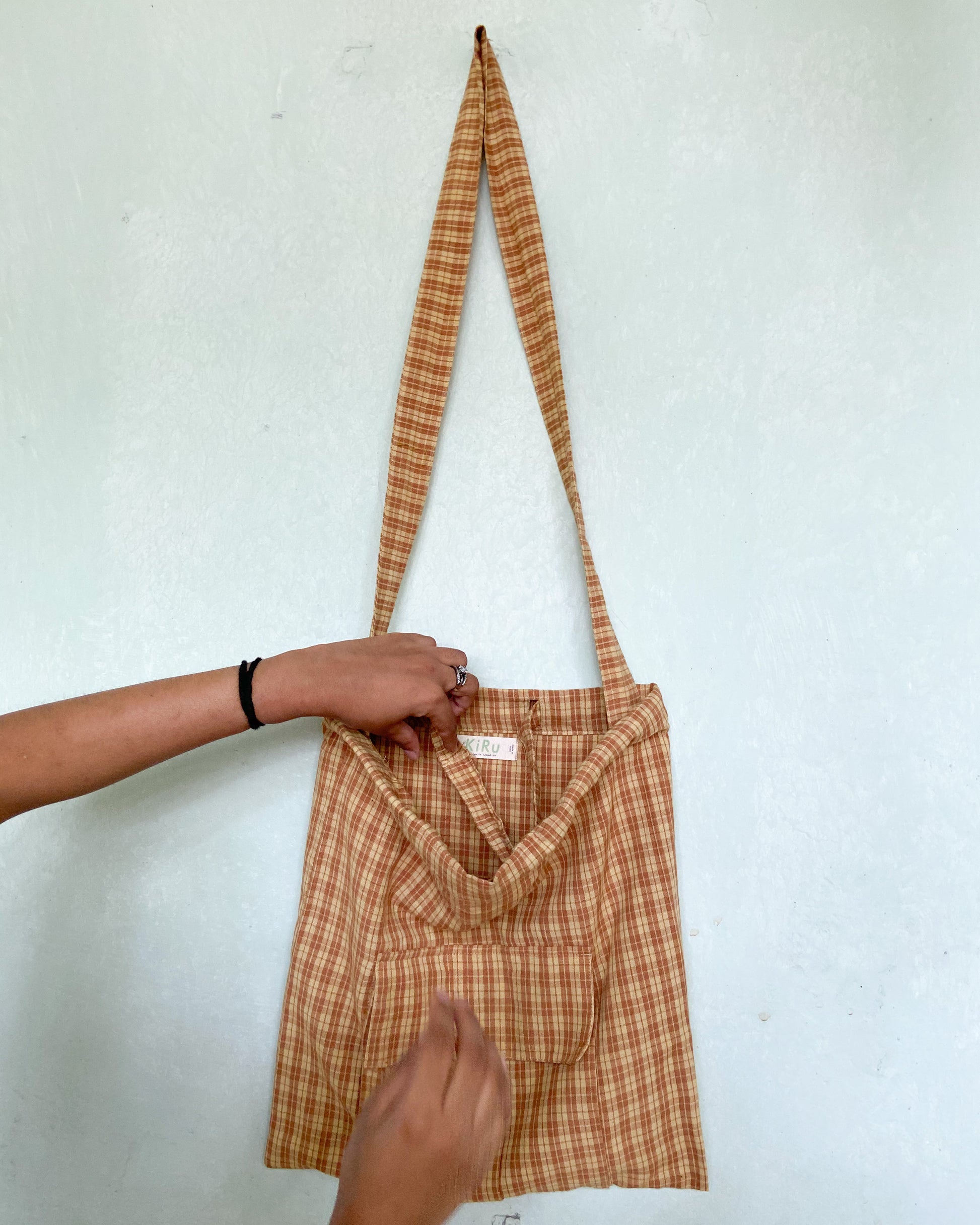 Yellow and Brown checks bag with two hands coming in  